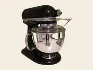 KitchenAid Artisan tilt-head stand mixer in black, with its steel bowl and pouring shield