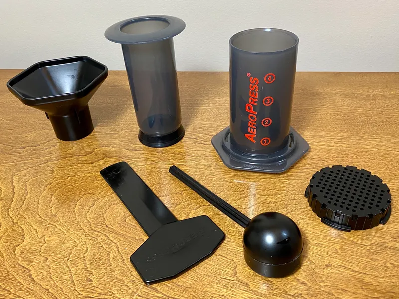 AeroPress coffee maker with its plunger, funnel, stirrer, scoop and filter cap